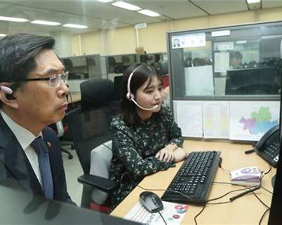 Immigration office interior with staff at desks assisting callers.