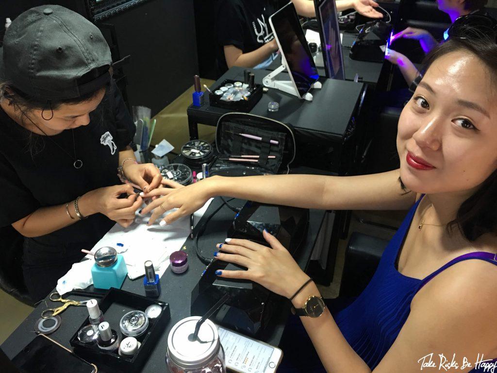 Smiling international customer having gel nail art applied by a Korean nail artist