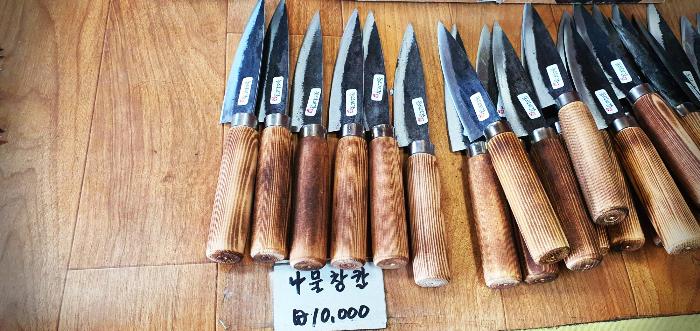 Hand-forged traditional Korean knives displayed for sale with a price tag
