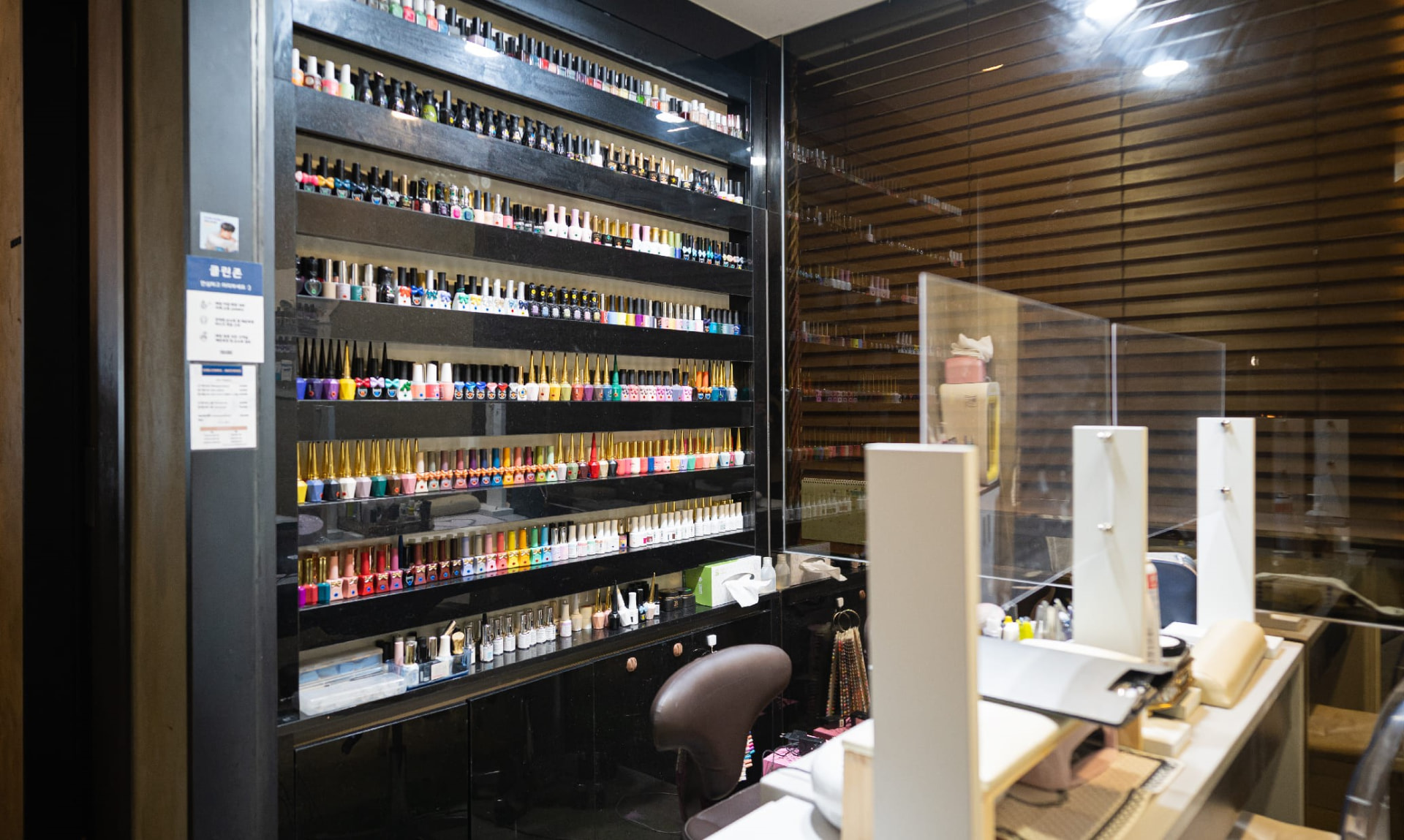 Colourful wall of nail polish bottles and a manicure station inside a Seoul nail salon