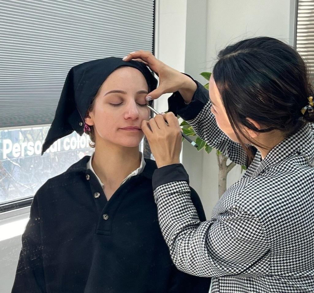 Foreign visitor receiving one-on-one professional makeup instruction in Seoul