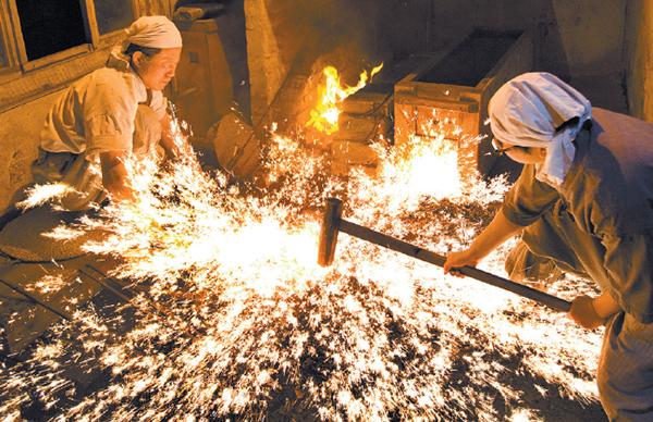 Two blacksmiths forging glowing iron together as sparks fly from the anvil