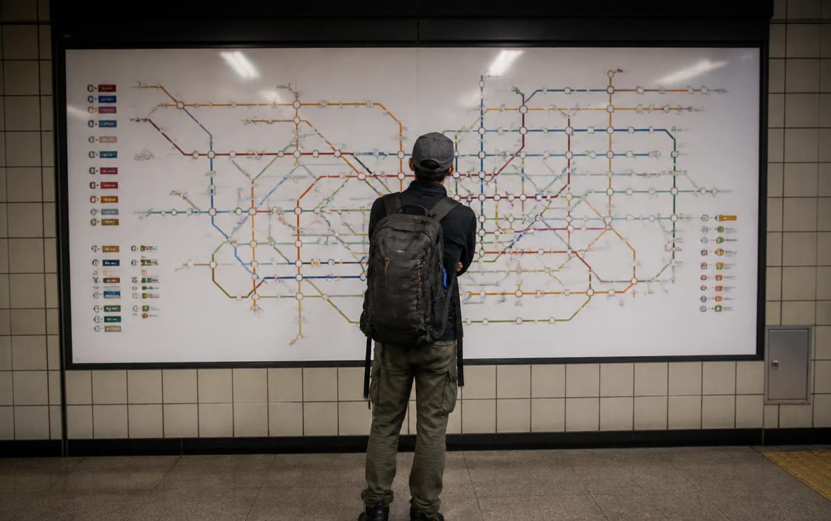 Traveller reading a Seoul subway line map inside a metro station